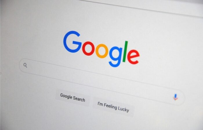 Seseorang sedang menganalisis grafik kenaikan trafik organik di halaman pertama pencarian Google pada layar monitor.